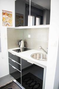 eine kleine Küche mit einem Waschbecken und einem Spiegel in der Unterkunft Piraeus Urban Paradise L in Piräus