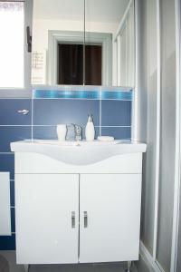 W łazience znajduje się biała umywalka i lustro. w obiekcie Piraeus Urban Paradise L w Pireusie