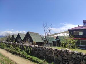 eine Reihe von Häusern hinter einer Steinmauer in der Unterkunft Birlik Yaylakent in Sultan Murat Yaylasi
