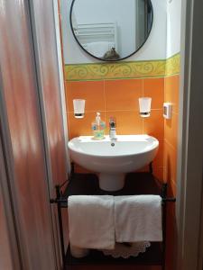 a bathroom with a white sink and a mirror at B&B Casa San Jacopo al Giardino in Lucca