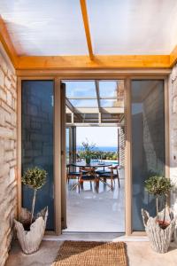 a glass extension to a house with a dining table at Villas Mandalos in Paleros