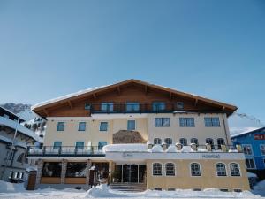 duży budynek z śniegiem przed nim w obiekcie Hotel Wagner w mieście Obertauern