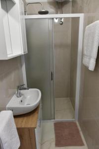 a bathroom with a shower and a white sink at Studio Apartments Kamicak in Sinj