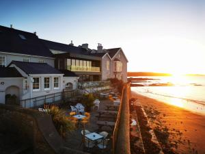 a building on the beach with tables and chairs at The Godolphin Hotel in Marazion