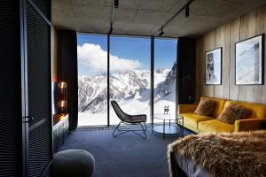 a living room with a view of a mountain at Tenir Eco Hotel, Shymbulak Mountain Resort in Almaty