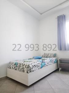 een slaapkamer met een bed in een witte kamer bij s+2 pied dans l'eau à dar allouche kélibia in Hanshīr Qaşr Ghallāb