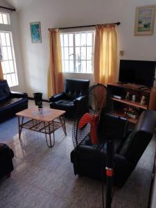 sala de estar con sofá, sillas y mesa en Ken Villa en Quatre Bornes