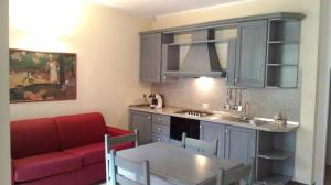 eine Küche und ein Wohnzimmer mit einem roten Sofa in der Unterkunft Carpediem Assisi in Piano Delle Pieve