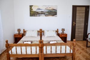 um quarto com uma cama de madeira e duas mesas de cabeceira em Apartment Nikola em Kotor