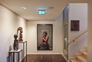 a hallway with a painting of a woman talking on a phone at AMERON Hamburg Hotel Speicherstadt in Hamburg