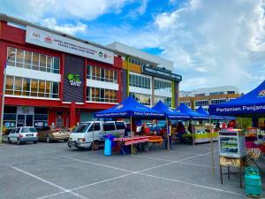 a market with blue umbrellas in front of a building at LS VILLAGE HOTEL in Padang Besar