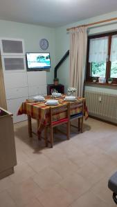 a living room with a wooden table and a table at Appartamento incantevole con ampio balcone in Sella Nevea