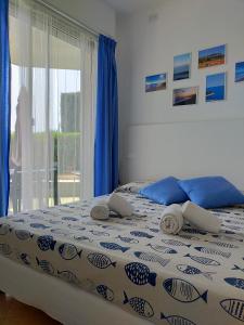 ein Schlafzimmer mit einem Bett mit blauen Kissen und einem Fenster in der Unterkunft Casetta alla Spiaggia Ventimiglia in Ventimiglia
