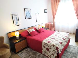 um quarto com uma cama com um edredão vermelho em Apartamento Tranquilo Zona Paseo de Lordelo - WIFI em O Grove