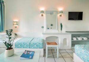 a bedroom with a bed and a table and a chair at Mitsis Cretan Village in Hersonissos