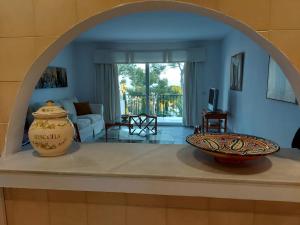einen Torbogen in einem Wohnzimmer mit zwei Vasen auf einer Theke in der Unterkunft Miraflores Resort in La Cala de Mijas