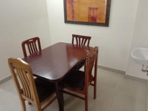a dining room table with four chairs and a sink at The Altruist Business Stays B-2 in Bangalore