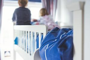 two children sitting on a crib in a room at Waves - Duplex Apartment Stoke Fleming in Stoke Fleming