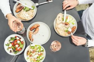 a group of people eating food on a table at Waves - Duplex Apartment Stoke Fleming in Stoke Fleming