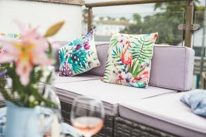a couch with pillows and a glass of wine at Waves - Duplex Apartment Stoke Fleming in Stoke Fleming