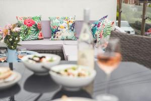 a table with plates of food and a glass of wine at Waves - Duplex Apartment Stoke Fleming in Stoke Fleming