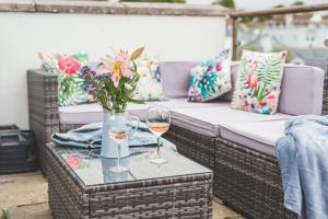 two glasses of wine on a table on a patio at Waves - Duplex Apartment Stoke Fleming in Stoke Fleming