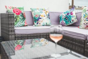 a glass of wine on a table with a couch and pillows at Waves - Duplex Apartment Stoke Fleming in Stoke Fleming