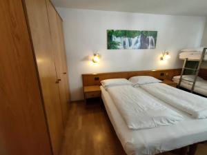 sypialnia z 2 łóżkami i 2 lampkami na ścianie w obiekcie Hotel Denny w mieście Pinzolo