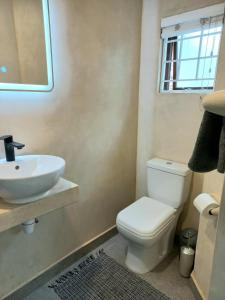 a bathroom with a toilet and a sink at Lazy Days Apartments - Jeffreys Bay in Jeffreys Bay