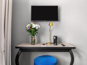 a table with a vase of flowers and a lamp at Numa Prague Root in Prague