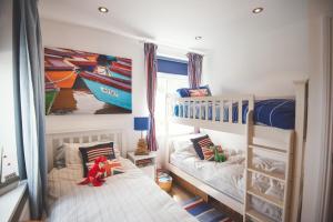 a childs bedroom with two bunk beds and a red toy at Waves - Duplex Apartment Stoke Fleming in Stoke Fleming