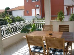 a wooden table and chairs on a balcony at Family Apartments Suzi in Rovinj