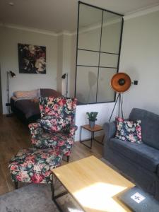 a living room with a couch and a chair at Apartament pod Świątynią Wang in Karpacz