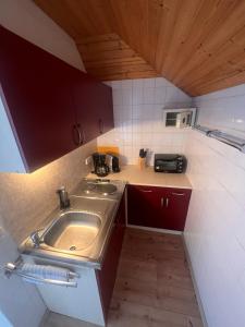a small kitchen with a sink and a microwave at Wörthersee Appartements Lex in Maria Wörth