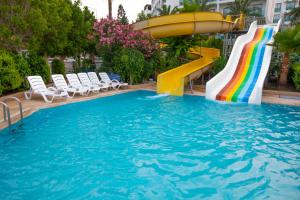 a pool with a water slide and a rainbow at Falcon Hotel in Antalya