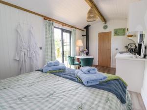 a bedroom with a large bed with towels on it at High Rigg Shepherd's Sunrise in Brampton