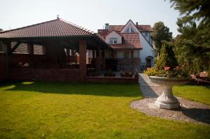 une maison avec une fontaine dans la cour dans l'établissement Noclegi U Kawalca, à Szczecinek