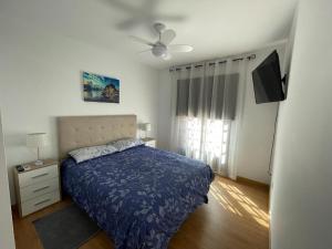1 dormitorio con 1 cama y ventilador de techo en Vacacional Arbelo Golf, en San Miguel de Abona