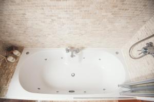 a white bath tub in a room with a brick wall at Waves - Duplex Apartment Stoke Fleming in Stoke Fleming