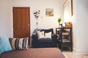 a living room with a couch and a chair at Waves - Duplex Apartment Stoke Fleming in Stoke Fleming