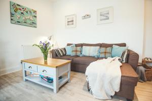 uma sala de estar com um sofá e uma mesa em Waves - Duplex Apartment Stoke Fleming em Stoke Fleming