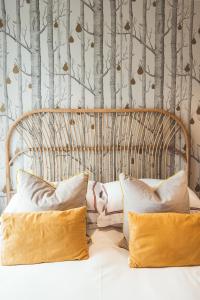 a bedroom with a wooden headboard with trees on the wall at Waves - Duplex Apartment Stoke Fleming in Stoke Fleming