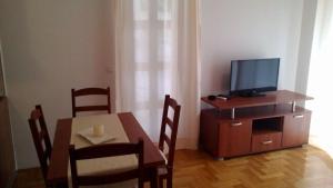 a dining room with a table and a television on a cabinet at Apartment Toni in Makarska