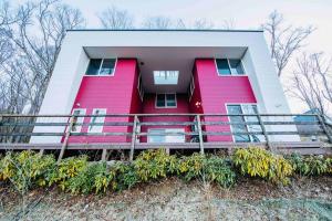 山中湖的住宿－Koti + Yamanakako，粉红色的房子,前面有栅栏