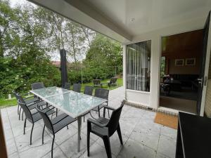 ein Glastisch und Stühle auf einer Terrasse in der Unterkunft Luitekamp Ameland in Ballum