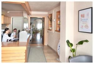 two people sitting at a counter in a kitchen at Tramas Hotel & Spa in Olbia