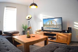 a living room with a tv and a coffee table at Ferienhaus Ruegenliebe 01 in Binz