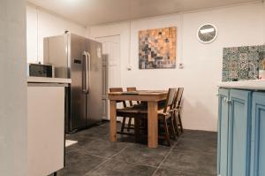 a kitchen with a wooden table and a refrigerator at sur la route du voile meublé hibiscus in Salazie