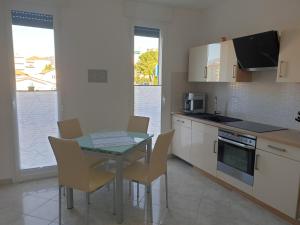 eine Küche mit einem Tisch und Stühlen in der Unterkunft Casa Marisa, 40 metri dalla spiaggia in Vallecrosia
