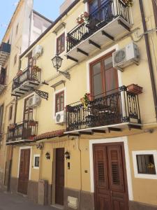 パレルモにあるHome Casa Professa 2の大きな黄色の建物で、通りに面したバルコニーとドアがあります。